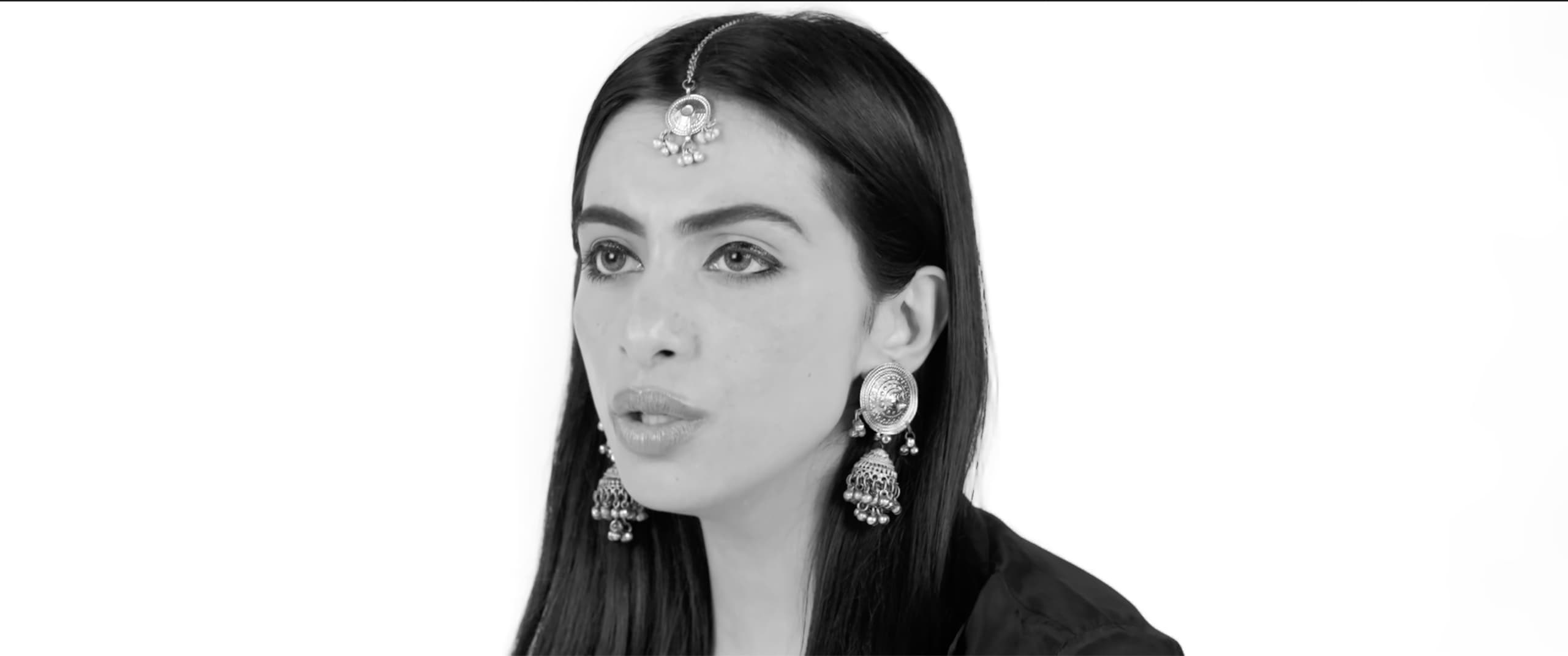 Black-and-white studio portrait of Ranjani mid-phrase, wearing a maang tikka